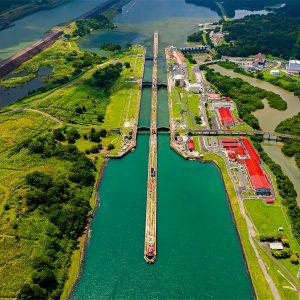 Imagen del Canal de Panamá con un barco en tránsito y paisajes verdes a su alrededor